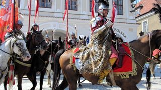 Historisch kostümiert und zu Pferd.